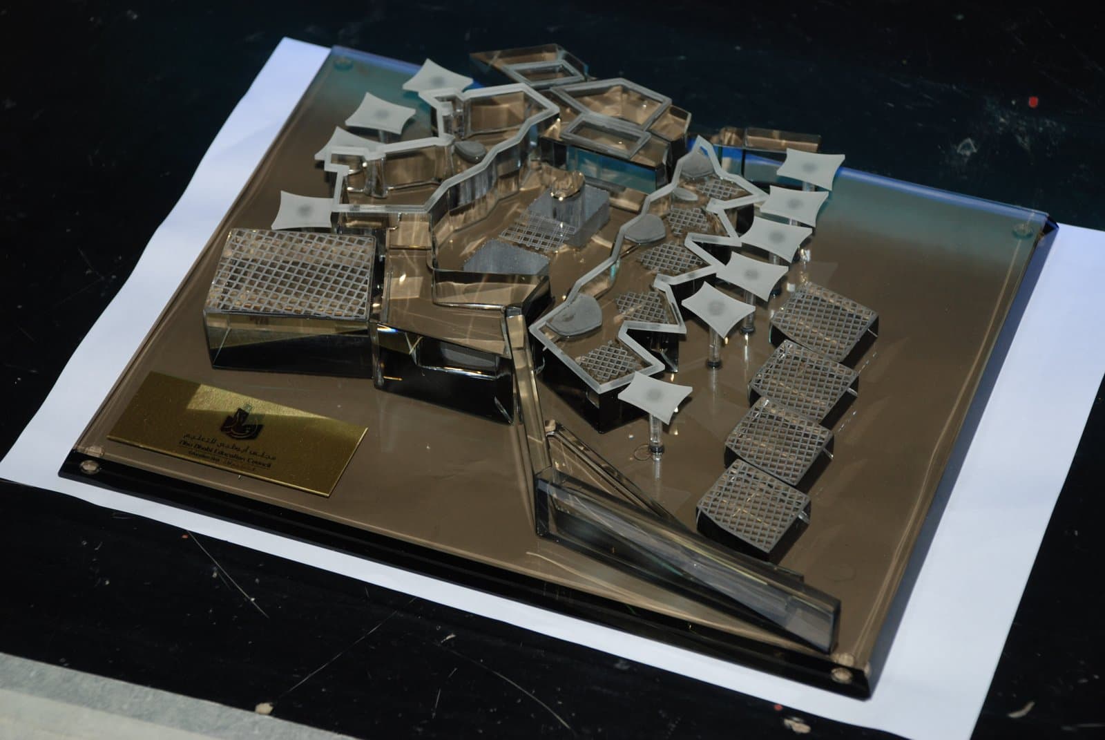 Airport building miniatures and layered roofs arranged on a dark rectangular board