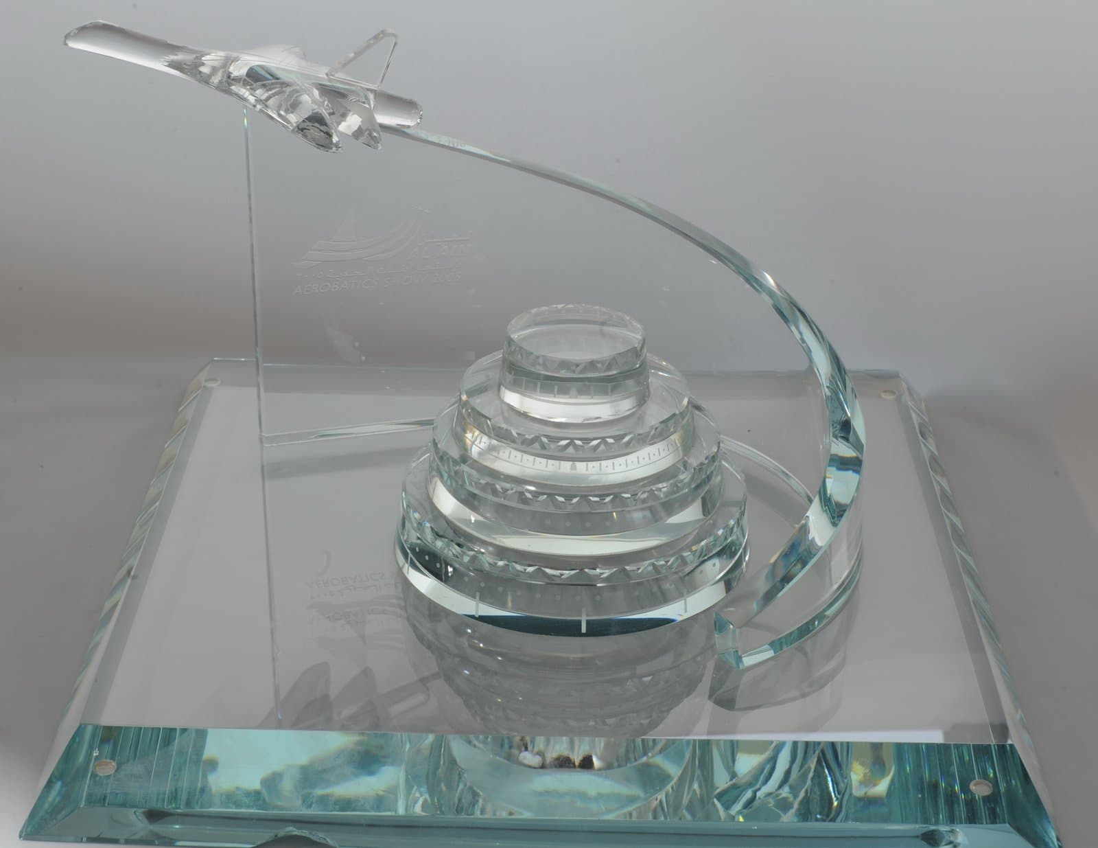 Clear aircraft on a curved support above a tiered circular building and square transparent platform