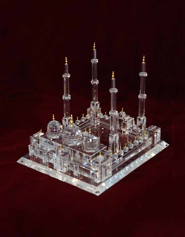 Detailed clear mosque miniature with domes, arches and tall minarets on a rectangular platform