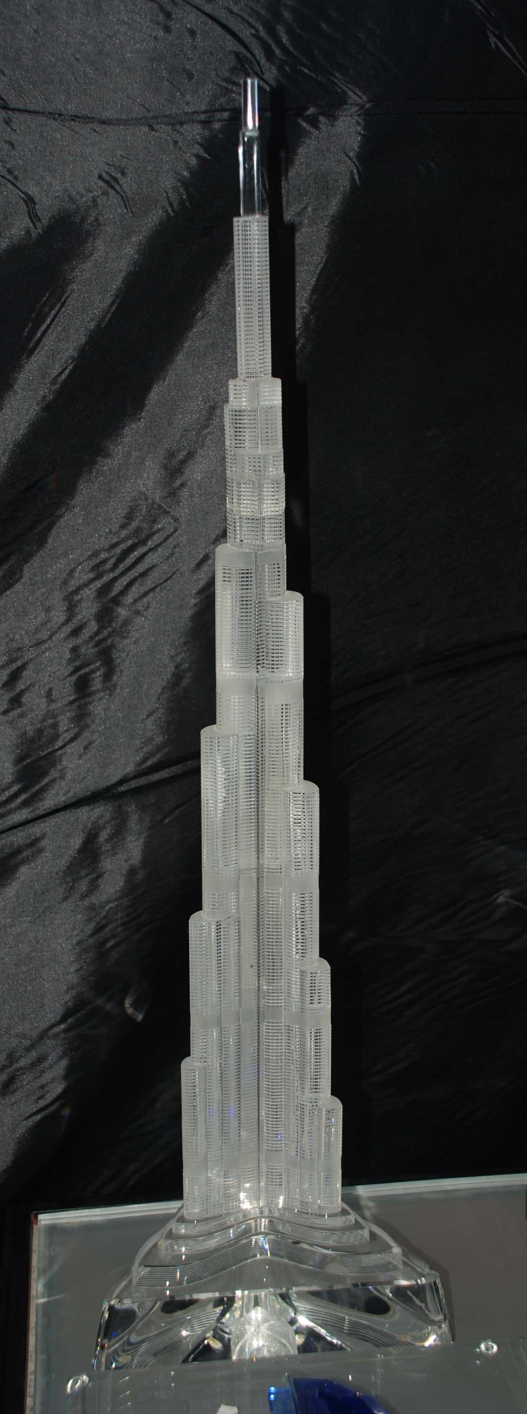 Tall clear tower with successive setbacks, a thin spire and a wider transparent foot