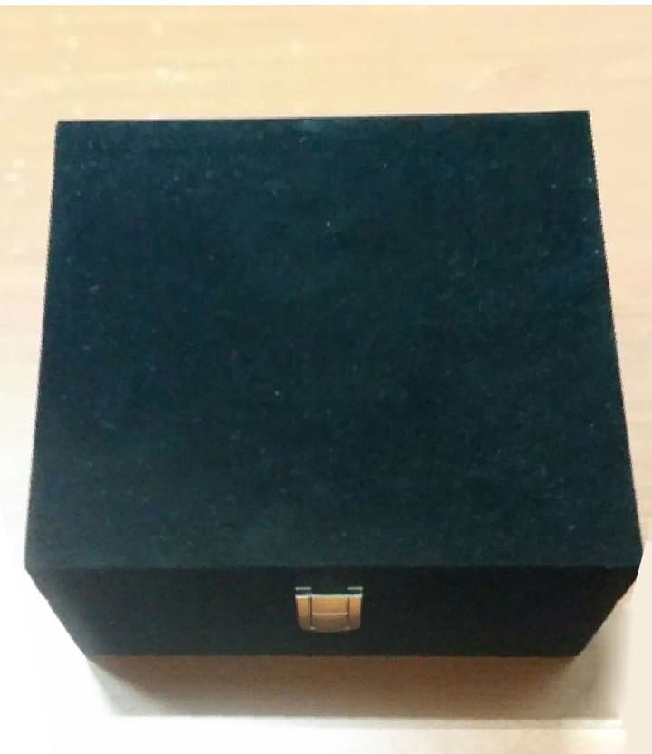 Closed black velvet presentation box with a small gold-toned front clasp