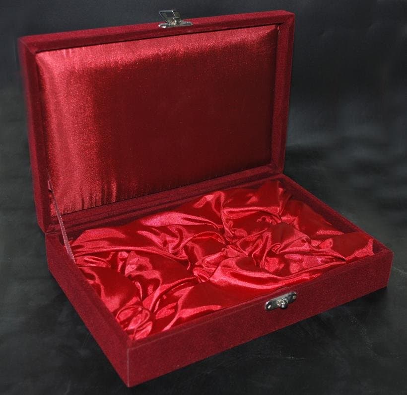 Open maroon velvet gift box with a raised lid and gathered red lining