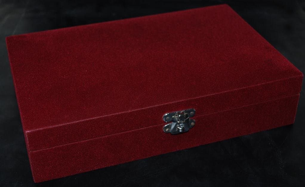 Closed rectangular maroon velvet gift box with a decorative silver-toned front clasp