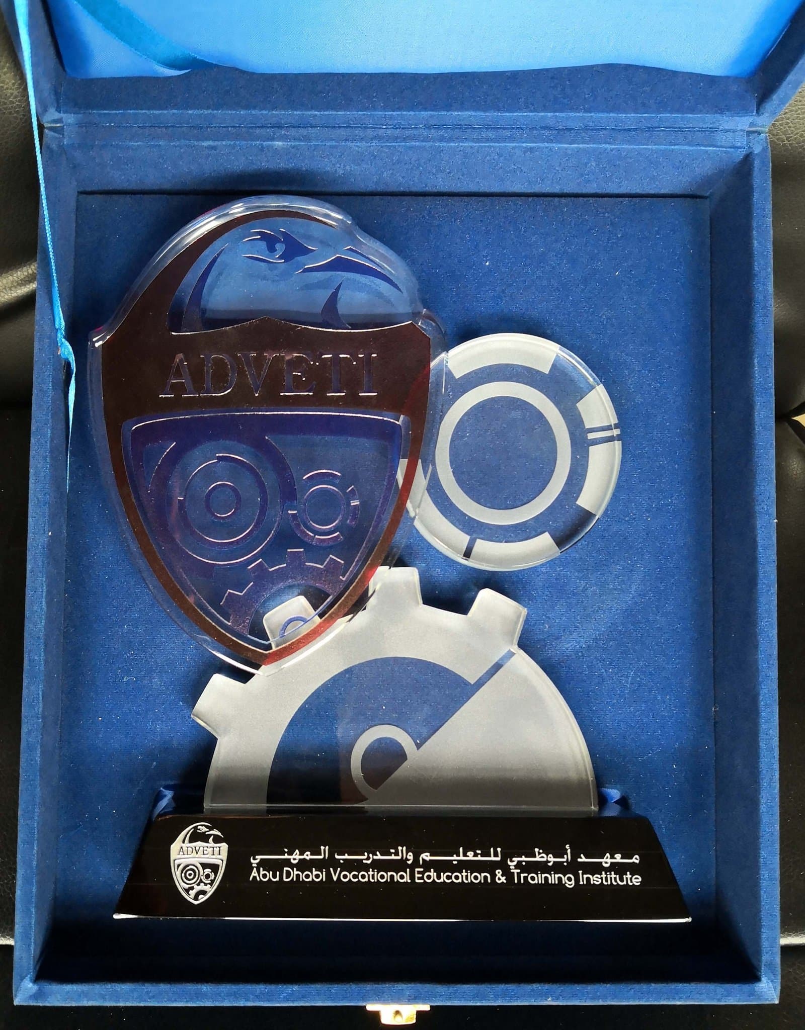 Blue shield and circular sports-emblem elements with pale curved accents on a dark base in a blue case