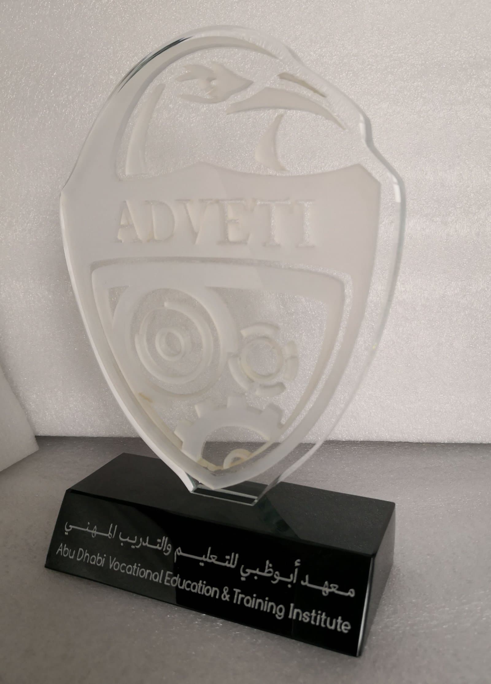 Clear shield-shaped engraved award with a rounded top and dark inscription base