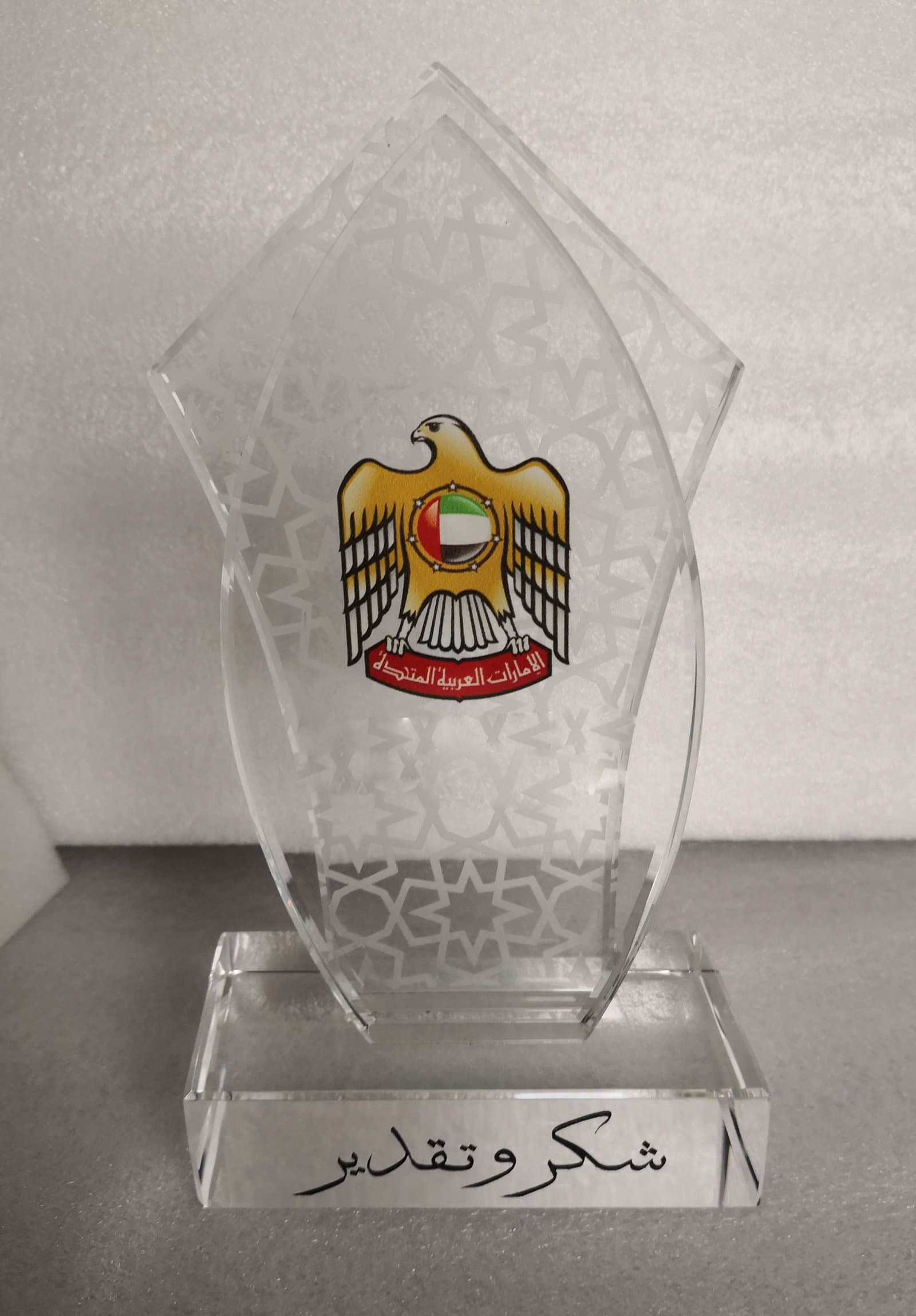Clear shield plaque with a colourful UAE emblem, fine lower decoration and a transparent base