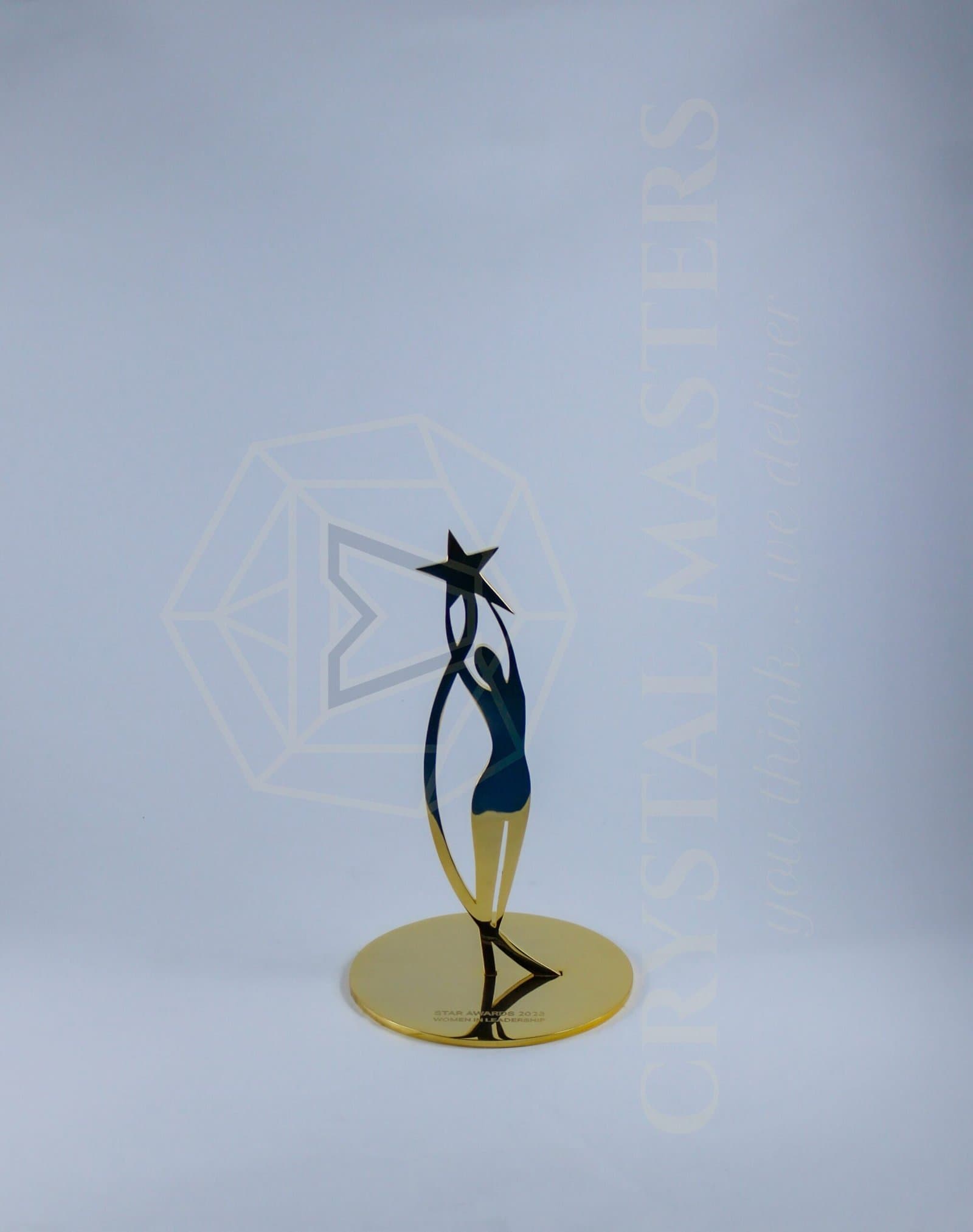 Dark slender figure-like metal trophy reaching toward a star on a gold-toned circular base
