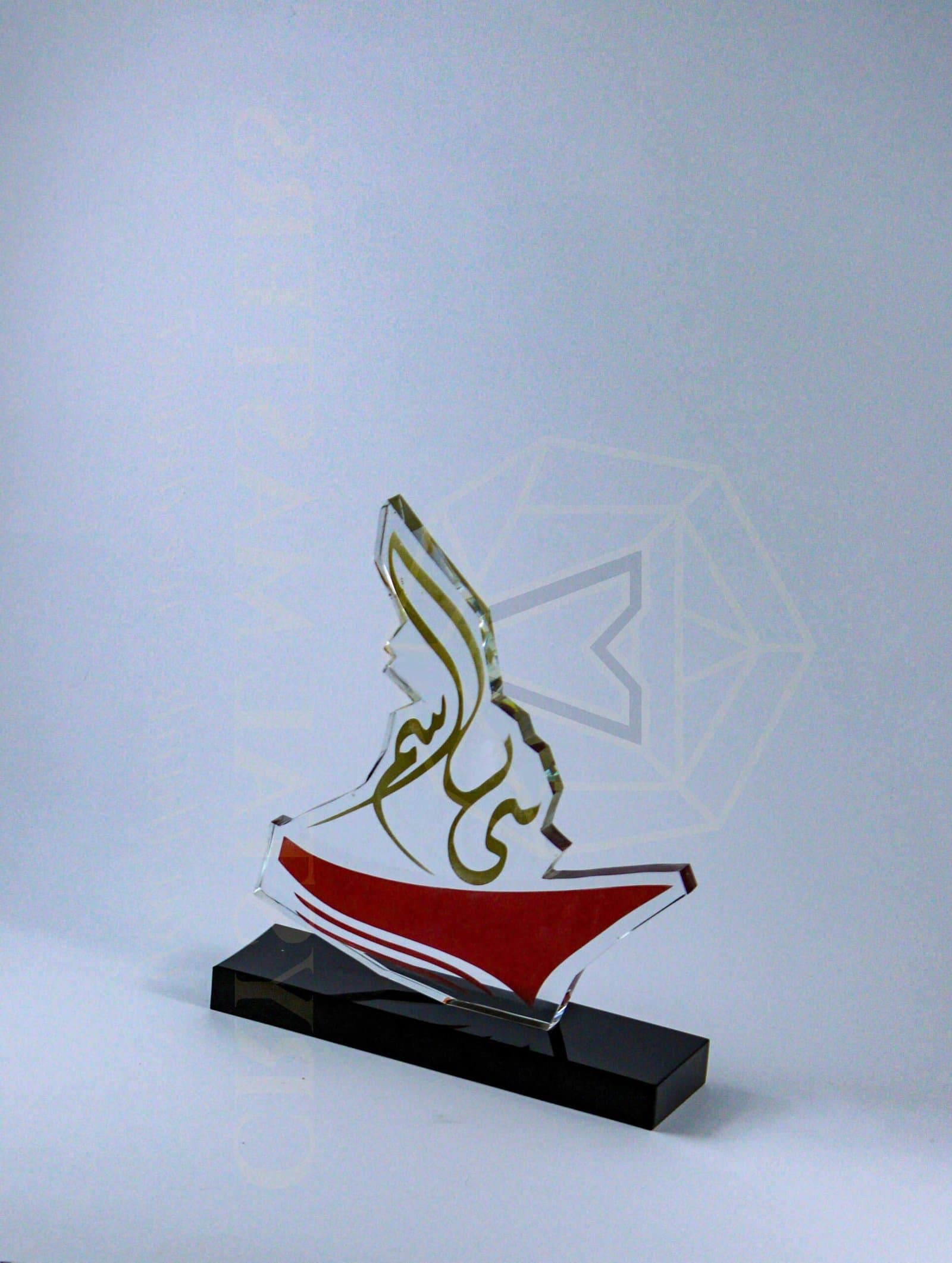 Tall open gold-toned calligraphic outline above red and green accents on a black base
