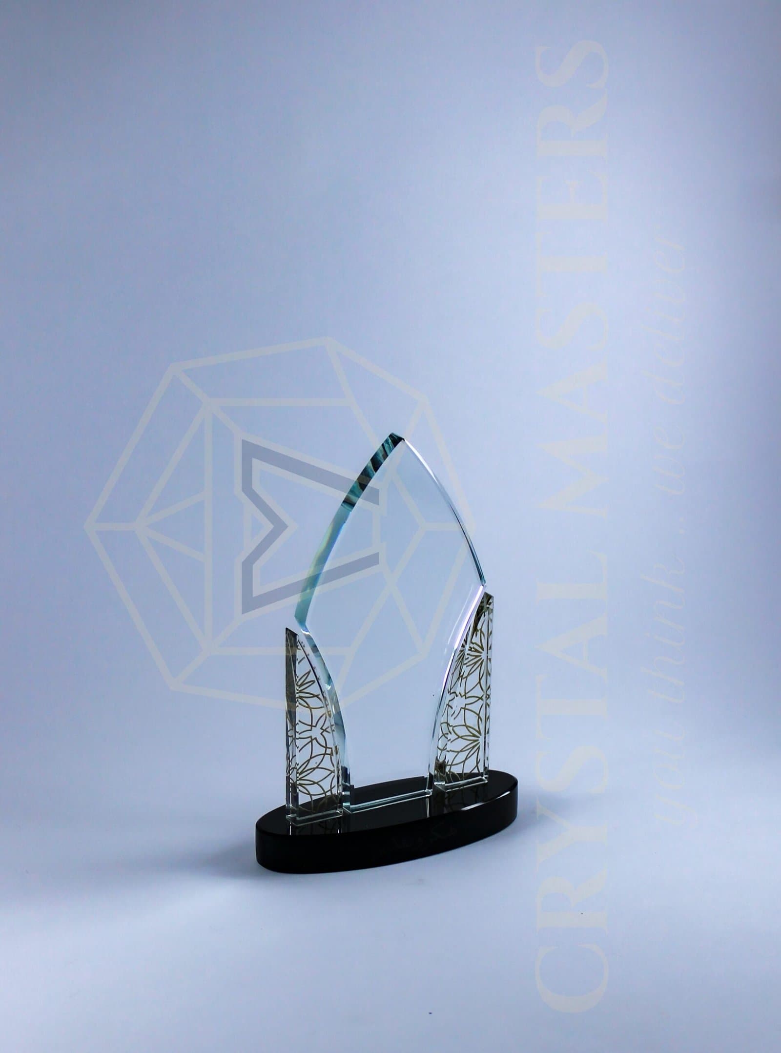 Pointed clear crystal panel between two patterned side panels on a dark oval base
