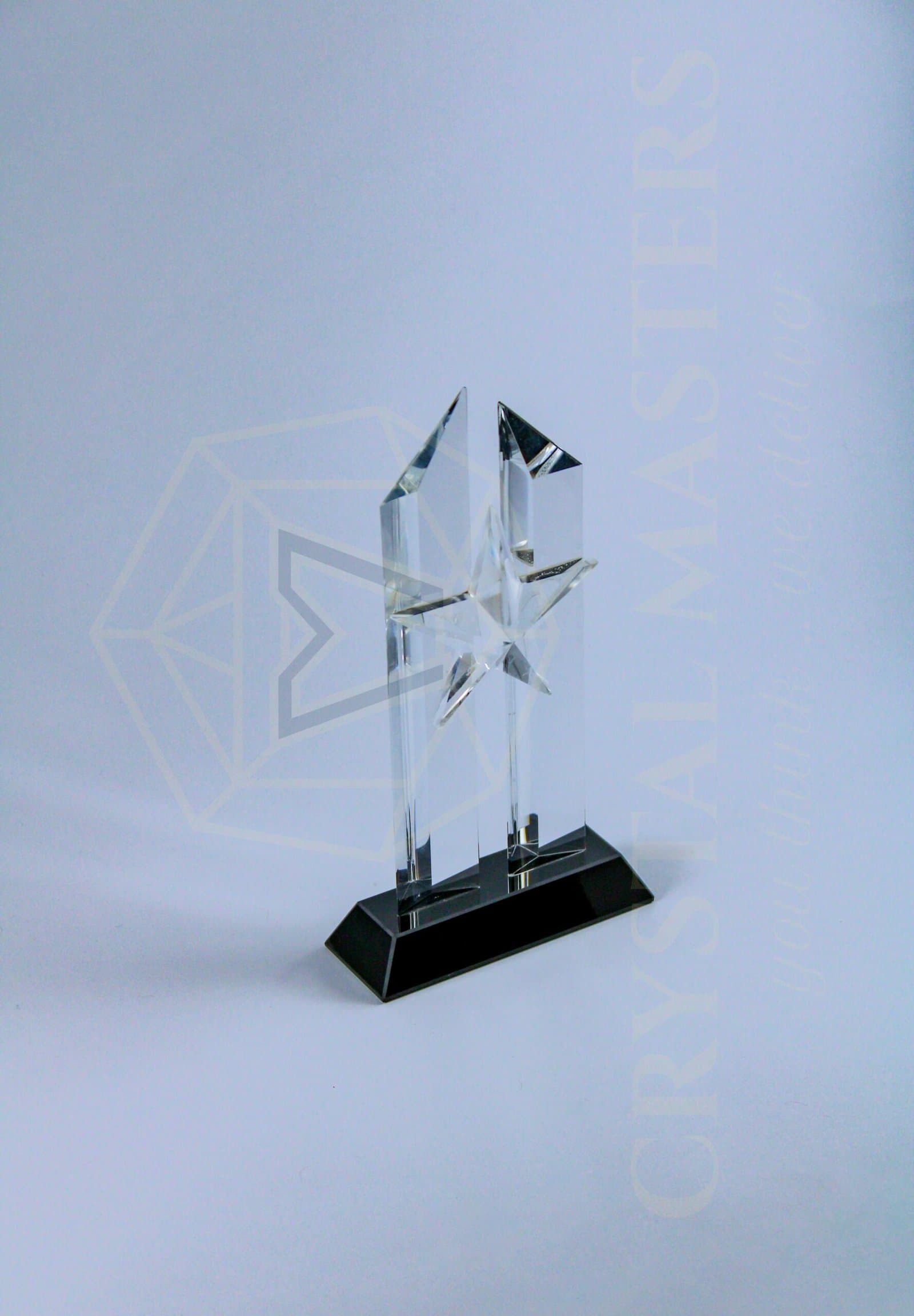 Tall angular clear crystal award with pointed upper edges and projecting facets on a dark base