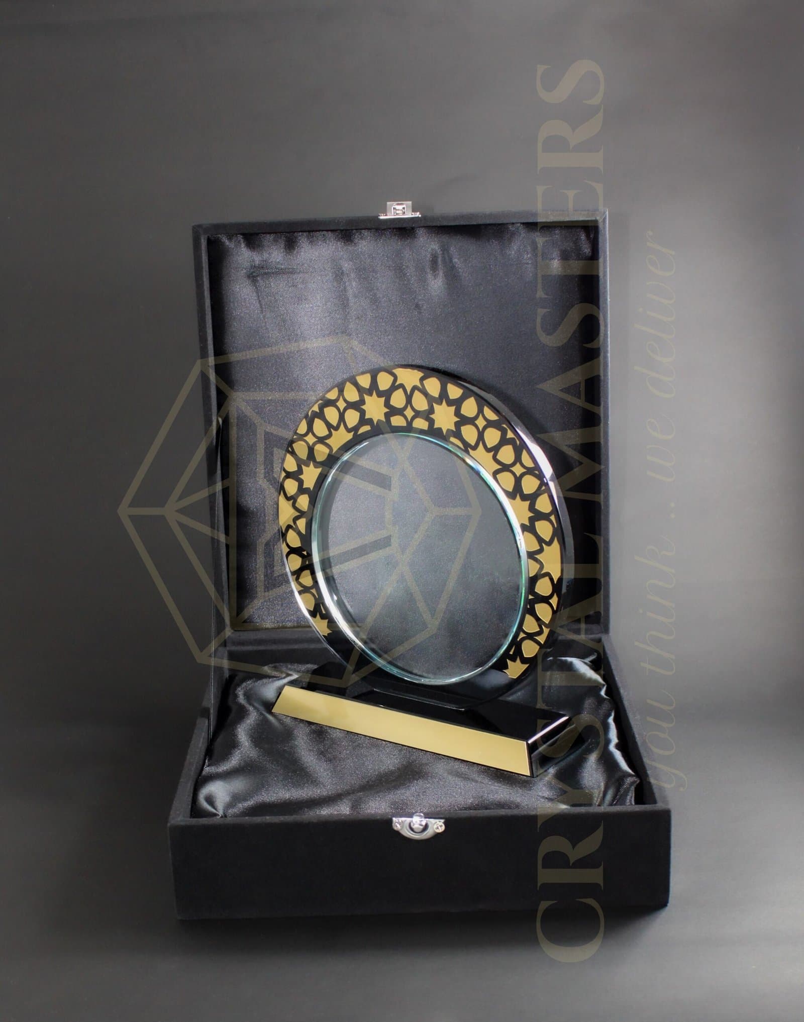 Round clear award with a patterned gold-toned border inside an open dark presentation box