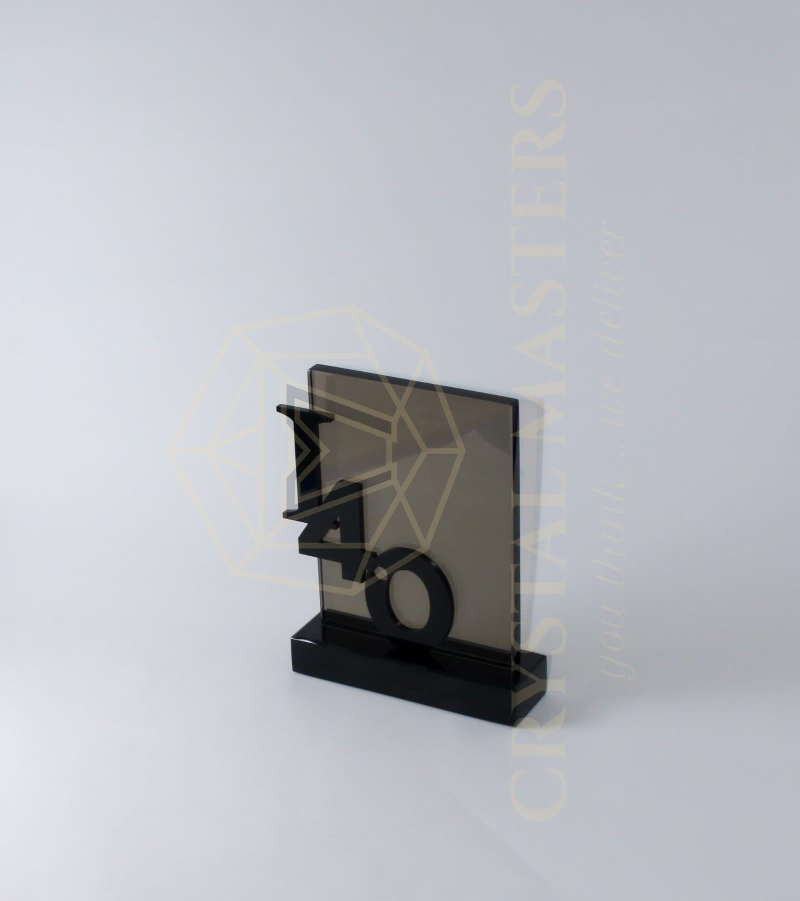 Smoke-toned rectangular plaque with dark projecting geometric shapes and an open circular accent