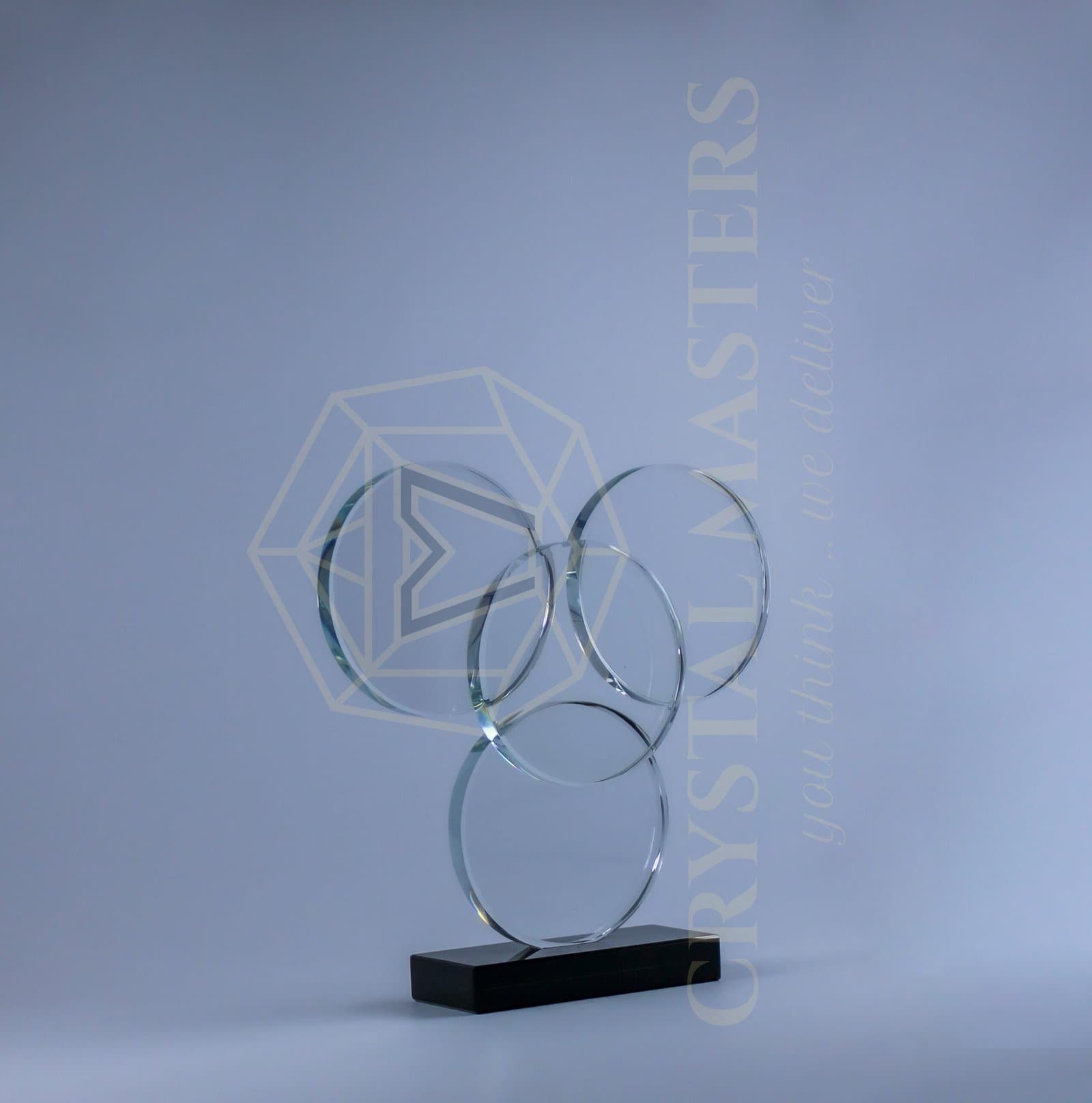 Overlapping clear circular award outlines in an open arrangement on a narrow dark base