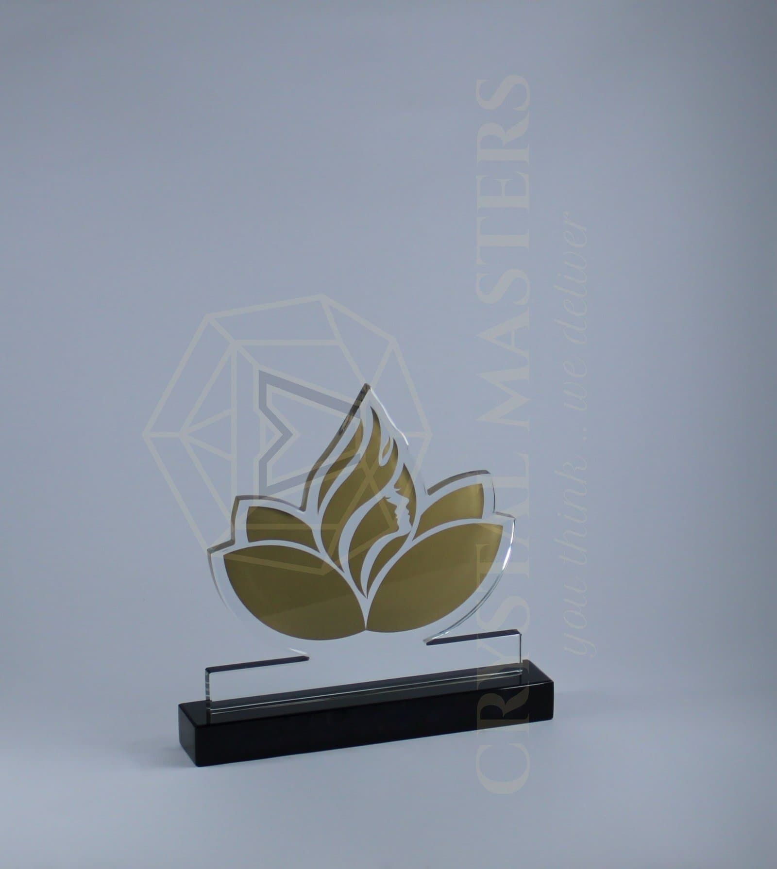 Layered gold-toned leaf-like award shapes with pale edges on a dark rectangular base