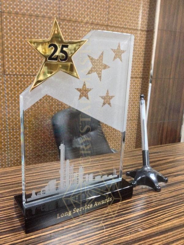 Anniversary display with a prominent 25, star motifs and a clear upright panel on a long base