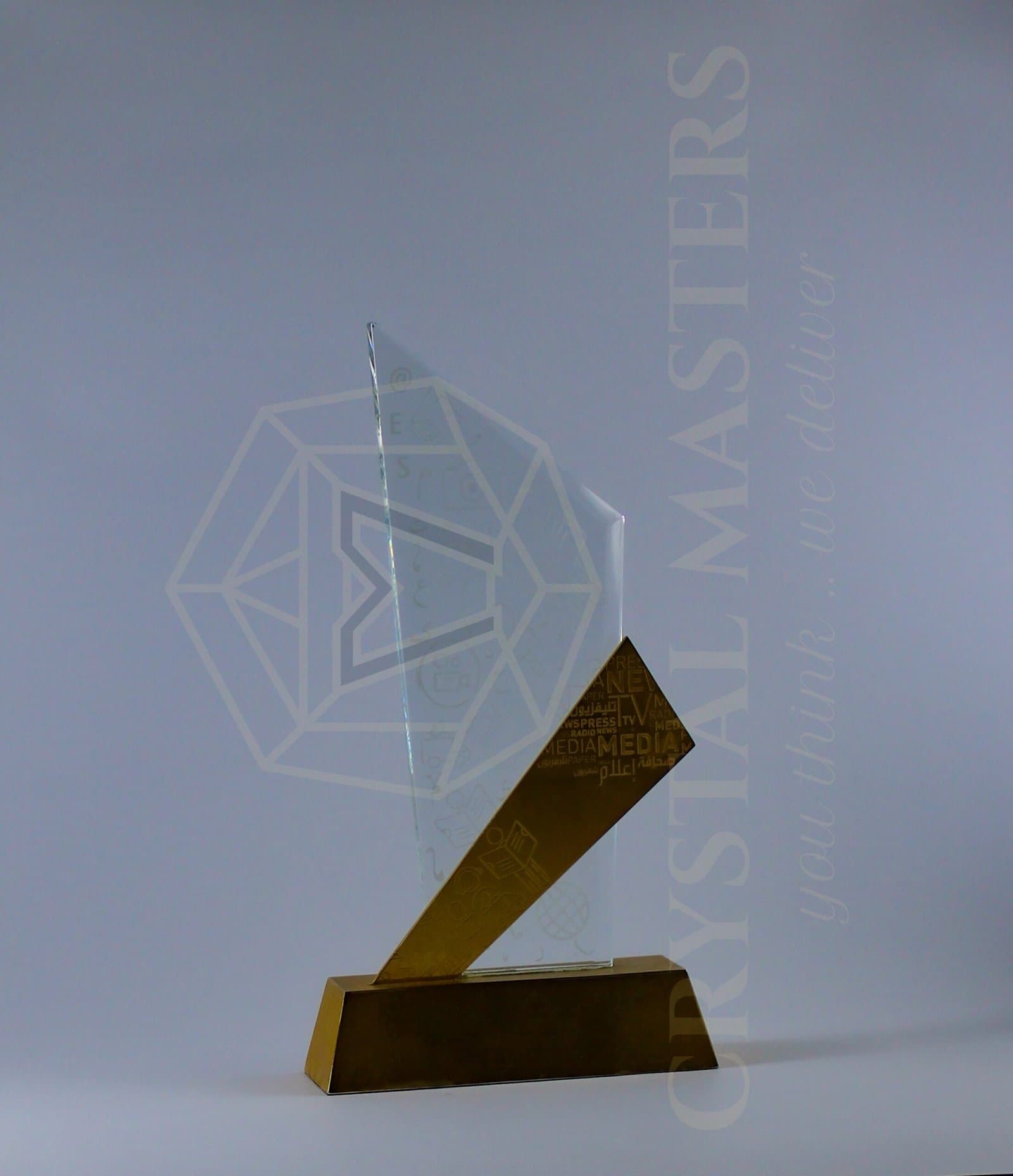 Clear triangular award intersected by a gold-toned diagonal element above a low warm-toned base