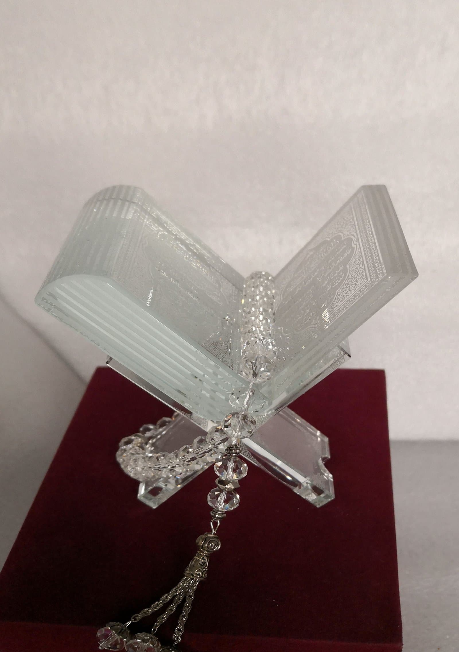 Clear open-book form on a crossed transparent stand with a hanging decorative tassel